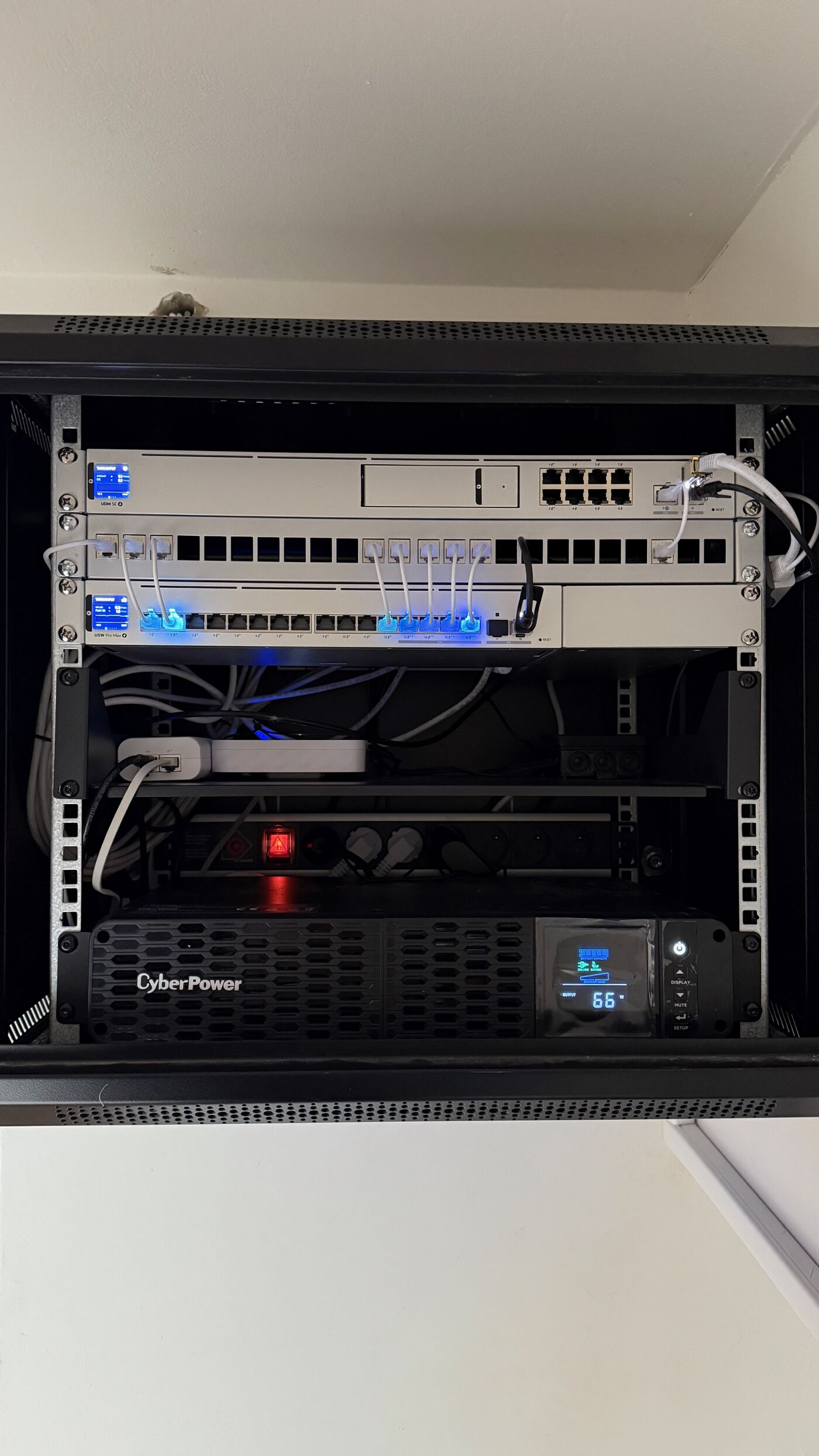 Datový rozvaděč s UniFi switchi, patch panelem a UPS — strukturovaná kabeláž kanceláří MECH.cz